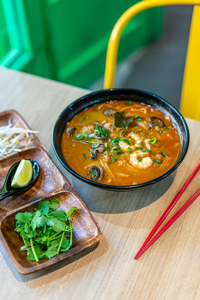 Sopa con leche de coco picante con sepia y gambas en Kiu Nam, restaurante vietnamita en Barcelona